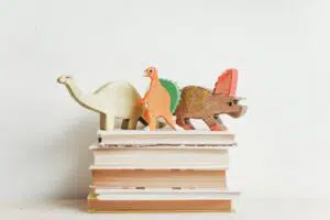 Dinosaurier-Figuren auf einem Stapel Bücher