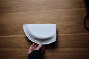 Foto: ein in der Mitte gefalteter Pappteller, eine Ecke ist zwischen die Hälften des Papptellers eingestülpt
