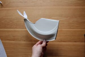 Foto: der nicht rausgeschnittene Teil der Zeichnung auf dem Pappteller wurde rausgestülpt, sieht aus wie eine Schwanzflosse