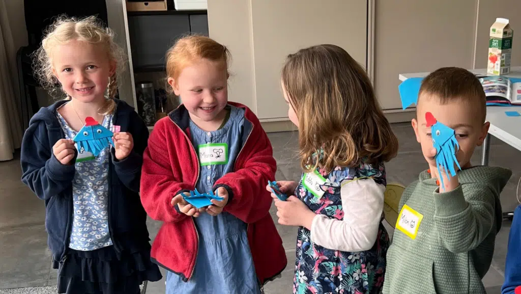 4 Kinder halten gebastelte Knotenklaus-Lesezeichen