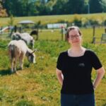 Foto: Anne Hanke auf einer Wiese mit zwei Eseln