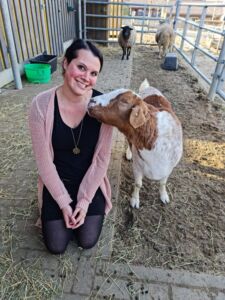 Foto: Hannah Schenk kniet neben einer Ziege